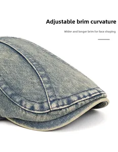 Detail of blue washed denim flat cap showing adjustable curved brim and contrast stitching
