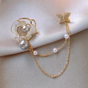 Detail view of 14k gold plated camellia brooch with grey pearls and butterfly charm