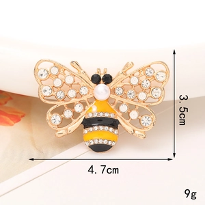 Macro detail of bee-shaped alloy accessory with rhinestones and pearl showing dimensions