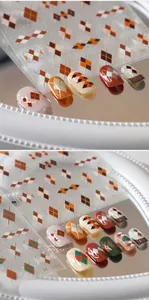 Macro detail of M-182 argyle pattern nail stickers with metallic accents and matte finish