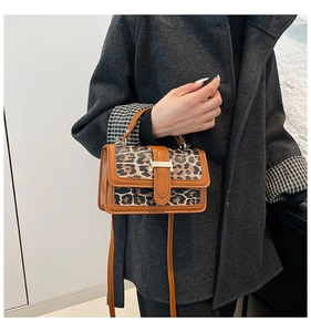 Detail of leopard print suede and brown leather handbag with gold metal lock