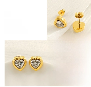Detail of gold heart earrings with zircon inlay showing polished finish and plating process