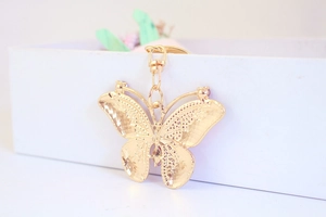 Macro view of gold butterfly keychain with sparkling rhinestone details and spring clip