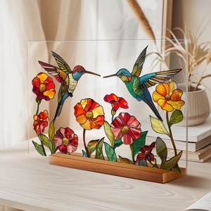 Detail of a transparent acrylic plaque featuring hummingbirds and a wooden base stand