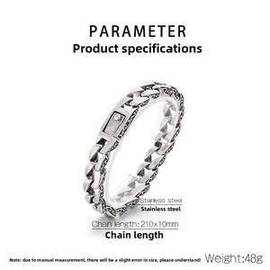 Macro detail of retro stainless steel chain bracelet with black embossed floral patterns
