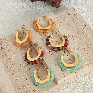 Vintage C-shaped titanium steel earrings with colorful natural stones on stone background