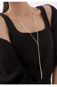 Close-up of elegant gold Y-shaped pull-out long snake chain necklace on model