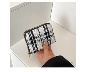Close-up of black and white tweed coin purse with a premium gold zipper detail