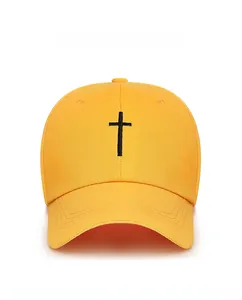 Close-up of a yellow cotton baseball cap with black cross embroidery and curved brim