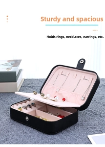 Detail of portable jewelry box with ring slots and necklace hooks in pink lining