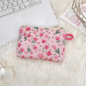 Detailed view of pink quilted fabric makeup pouch with tulip pattern on soft plush background