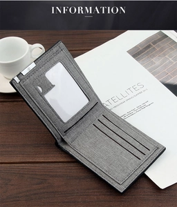 Detail view of grey fabric men's bifold wallet with card slots on dark wooden table