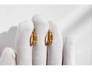 Macro shot of gold plated bamboo joint hoop earrings with shimmering cubic zirconia stones