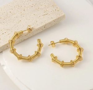 Macro detail of 18K gold plated hollow irregular twisted geometric hoop earrings