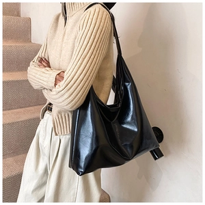 Dettaglio della texture in pelle PU nera lucida e design della borsa hobo da donna