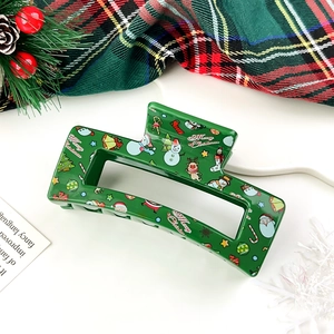 Detail of Christmas hair claw clip with reindeer and snowman print on green acrylic
