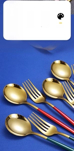 Detailed shot of mirror-polished gold stainless steel fork and spoon with green handles