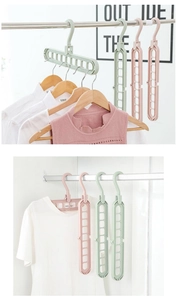 Macro detail of rotating 9-hole clothes hanger in green and pink for closet space saving
