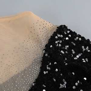 Detail of sequins and silver rhinestones stitching on mesh fabric of elegant dress