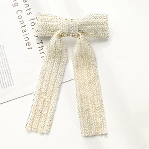 Detailed shot of handmade pearl beaded bow hairpin with elegant silver sequin patterns