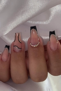 Detail of nude ballet nails with black French tips, silver glitter, and rhinestone decor