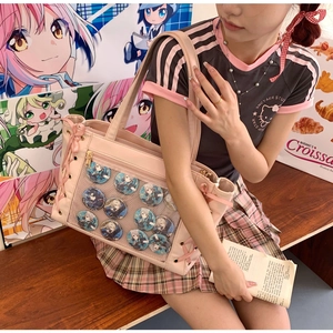 Detail of pink ita bag with transparent window and bow decoration shown on a model