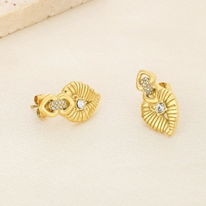 Close-up of gold heart and leaf earrings with sparkling clear zircon inlay details