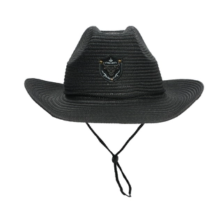 Detail of black woven cowboy hat featuring a bull head emblem and adjustable chin strap