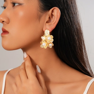 Close-up of elegant 18K gold plated flower earrings with pearls worn by a model
