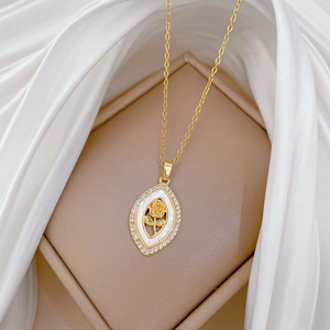 Détail du collier rose dorée avec entourage de diamants et nacre sur satin