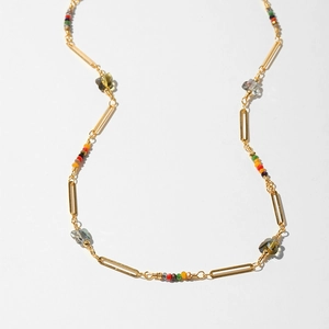 Detail of bohemian necklace with colorful beads and butterfly crystal pendants on gold chain