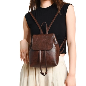 Minimalist vintage dark brown leather backpack with drawstring closure and flap cover