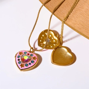 Detail view of heart-shaped locket necklace with pink enamel and blue crystals