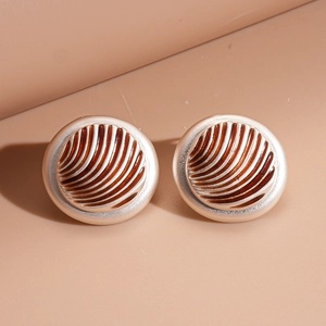 Detailed view of vintage round stud earrings with caramel enamel and golden radial texture