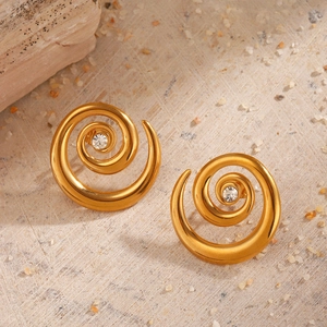 Minimalist gold spiral stud earrings with clear crystal set on natural stone background