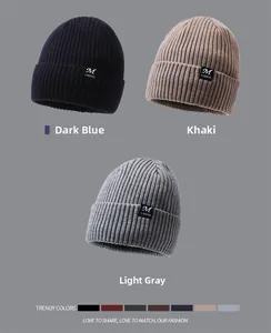 Detailed knit texture of blue, khaki and grey beanies with sewn logo labels