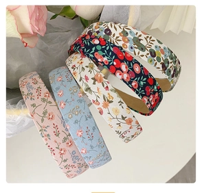 Flat lay of five assorted floral fabric headbands in various colors for women