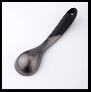 Macro detail of polished metal ice cream scoop head with textured black ergonomic handle