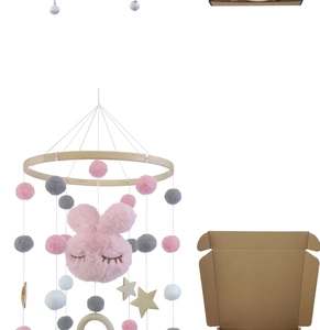 Detail of wooden baby mobile with plush bunny head, felt balls, and star charms in box