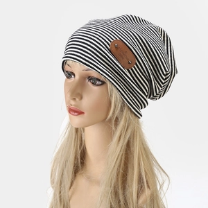 Retro black and white striped knit slouchy beanie with brown leather patch for a stylish look