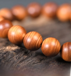 Macro detail of aged Thuja sutchuenensis wood beads showing natural oily texture