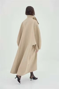 Rear view of long beige wool coat with loose silhouette and stylish back slit detail