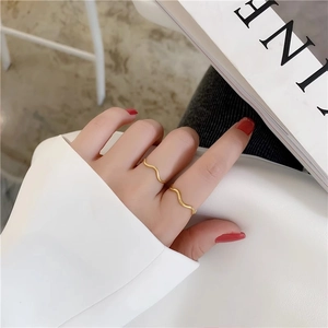 Minimalist gold wave rings set in titanium steel for women worn as stylish knuckle rings