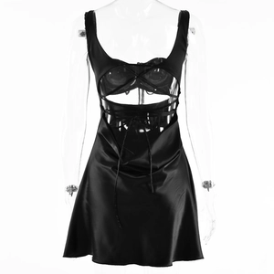 Detailed back view of a black satin slip dress with crisscross lace-up open back design