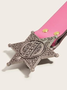Macro shot of pink leather belt featuring a vintage silver sheriff star buckle detail