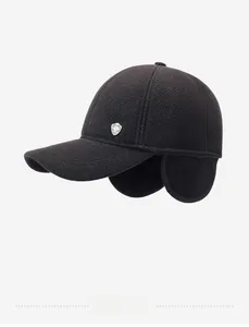 Detailed view of winter black twill baseball cap with warm earflaps and metal emblem