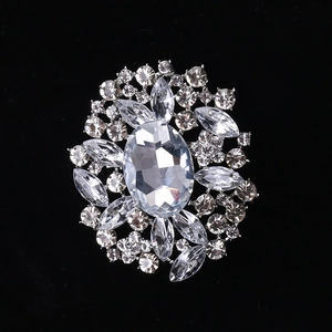 Detail of flower brooch with oval crystal centerpiece and marquise rhinestones on silver base