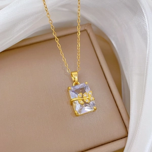 Detail of gold leaf pendant with rectangular clear gemstone in a luxury jewelry box