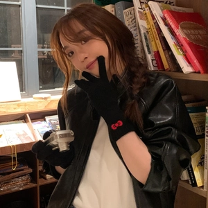 Women's black gloves with red Hello Kitty bow detail paired with a black leather jacket