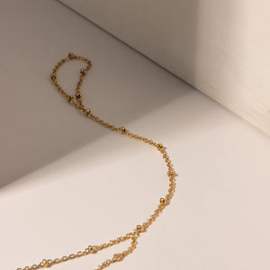 Detailed close-up of 18k gold plated stainless steel bead chain ring with shadow effect